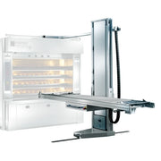 A commercial bakery oven shown with an automated oven loader and unloader on a plain white background. The oven door is open, revealing shelves with baked goods inside.
