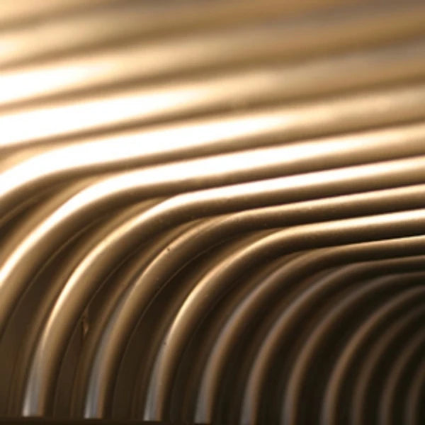 Close-up of curved metallic tubes of Empire Bakery Equipment's deck oven vapor tube heating technology. 
