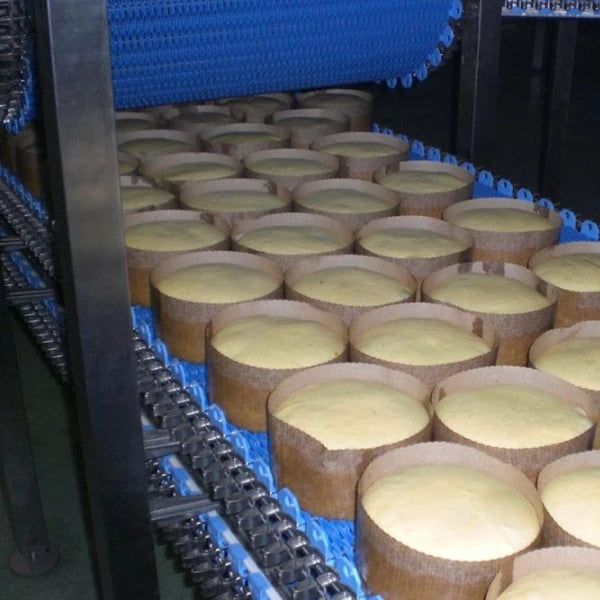 bread being moved through an industrial spiral proofing system