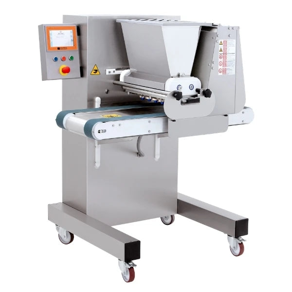 A commercial cookie depositing machine with a gray metal body, wheeled base, hopper on top, conveyor belt, and an attached control panel with a digital screen and red, yellow, and green buttons.